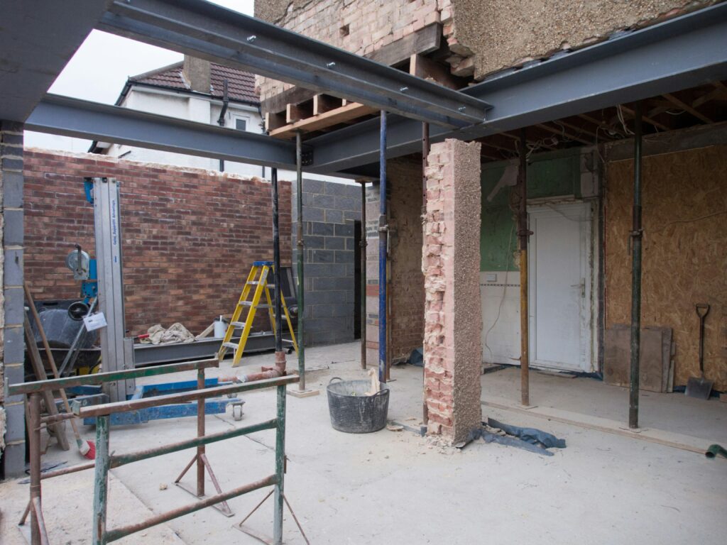 A decorative brick arch being constructed over a window opening, demonstrating heritage masonry techniques combined with modern structural steel lintels.