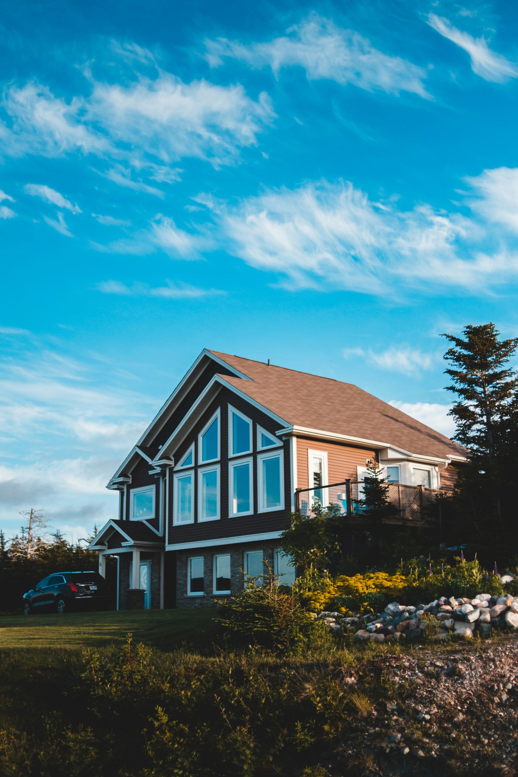 A full exterior view of a refurbished Cumbrian home with updated masonry, new roofing, and modern window installations, showcasing a successful structural and aesthetic transformation.