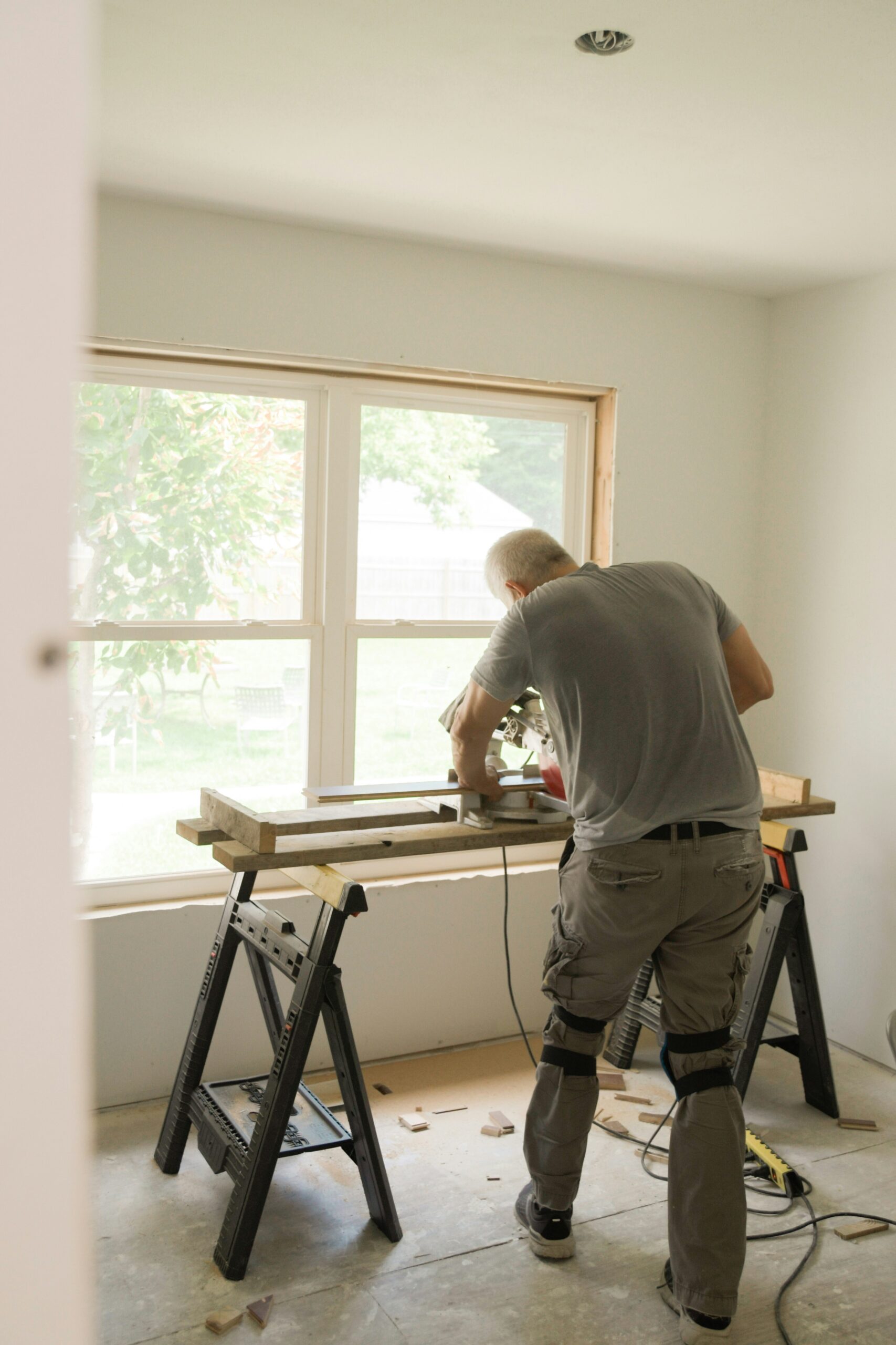 A craftsman performing detail work on an interior window alcove, highlighting the meticulous finishing stages of a premium Cumbrian home renovation.
